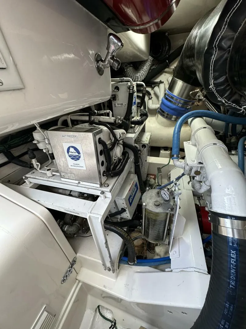 Slide: The Image of Engine room of 2006 Cabo 48 Convertible yacht, showcasing mechanical components and piping. - 35