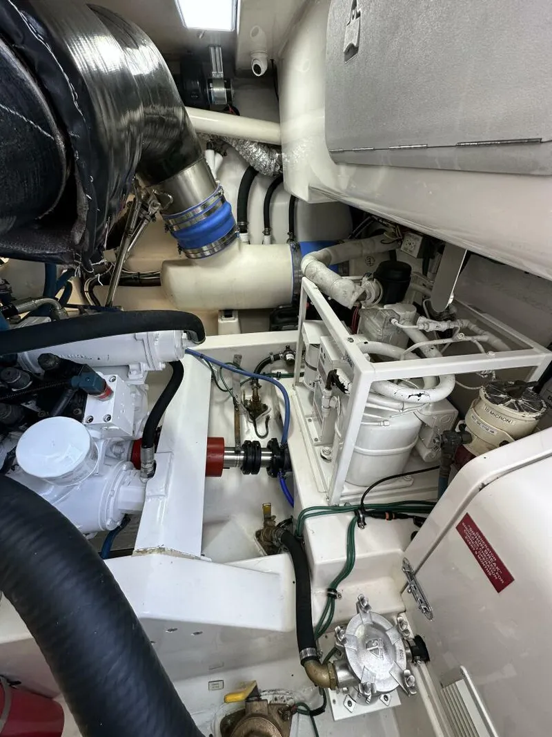 Slide: The Image of Engine room of a 2006 Cabo 48 Convertible yacht, showcasing mechanical components and piping. - 36