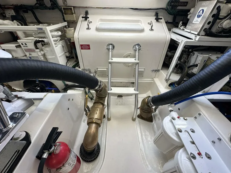 Slide: The Image of Engine room of 2006 Cabo 48 Convertible yacht with visible equipment and fire extinguisher. - 37