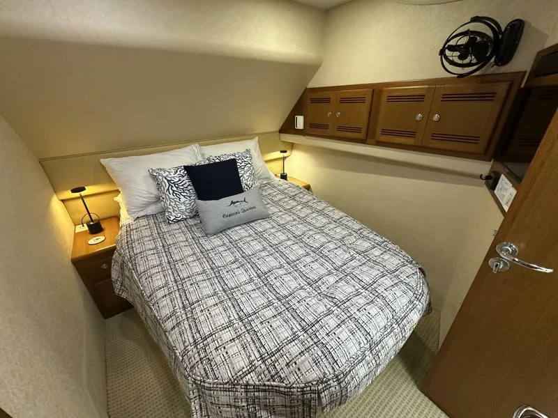 Slide: The Image of Cozy bedroom in 2006 Cabo 48 Convertible yacht with patterned bedding and wooden cabinets. - 4