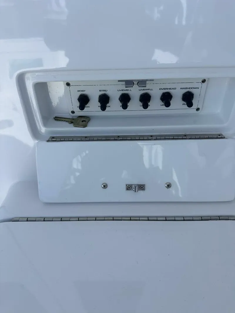 Slide: The Image of Control panel on a 2006 Cabo 48 Convertible boat with labeled switches and a key. - 42