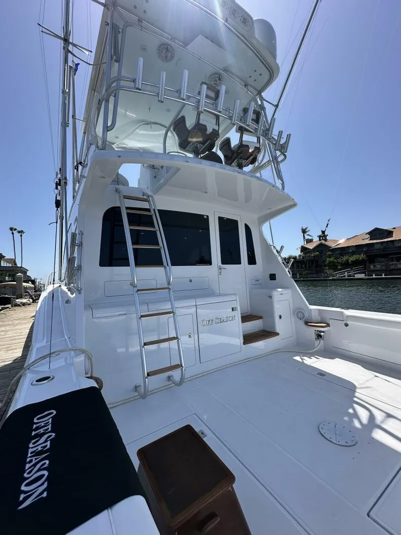Slide: The Image of 2006 Cabo 48 Convertible yacht with ladder and seating, docked under clear blue sky. - 43