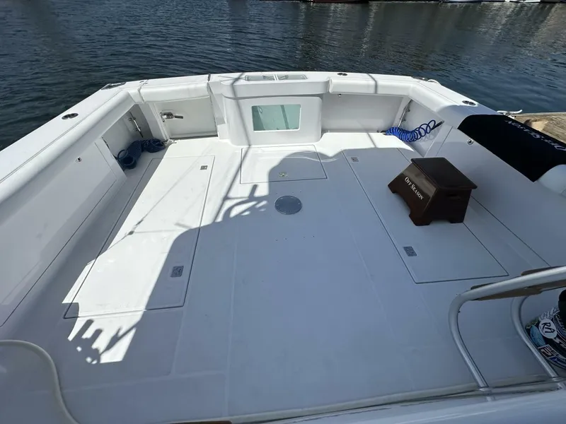 Slide: The Image of Spacious deck of 2006 Cabo 48 Convertible yacht, featuring clean white surface and dockside view. - 44