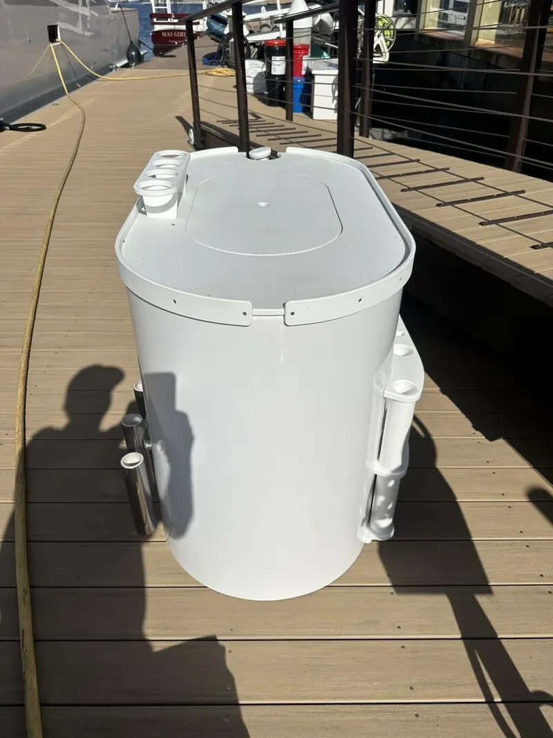 Slide: The Image of White cylindrical container on a wooden dock, near a Cabo 48 Convertible yacht. - 49