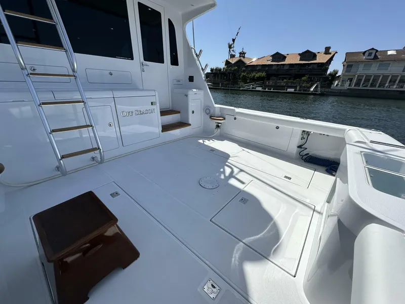 Slide: The Image of 2006 Cabo 48 Convertible yacht deck with ladder, docked near waterfront homes. - 5