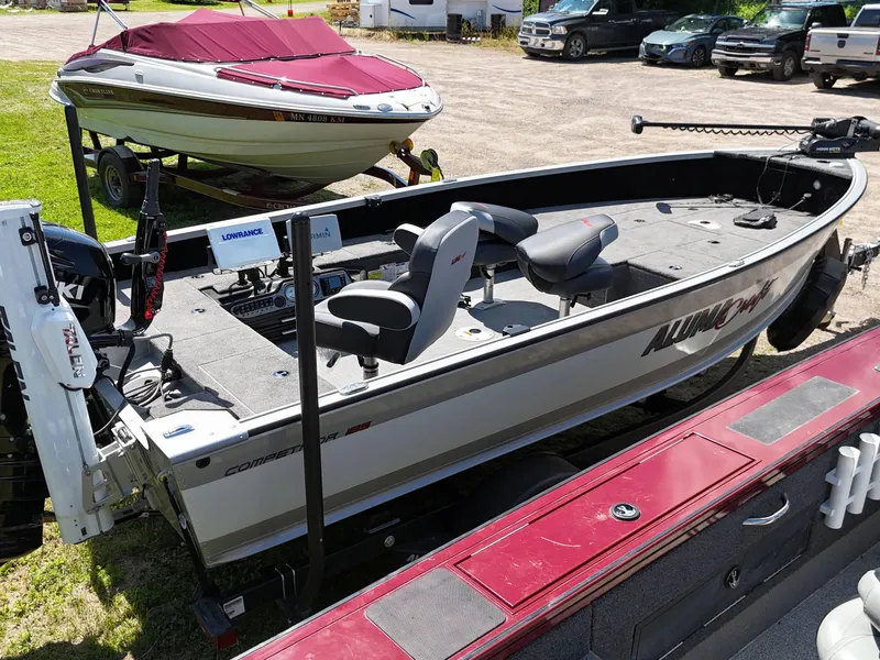 Slide: The Image of 2023 Alumacraft Competitor 185 Tiller boat with modern equipment, parked outdoors. - 11
