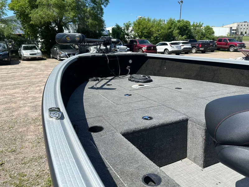 Slide: The Image of 2023 Alumacraft Competitor 185 Tiller boat interior with seating and equipment, parked outdoors. - 26