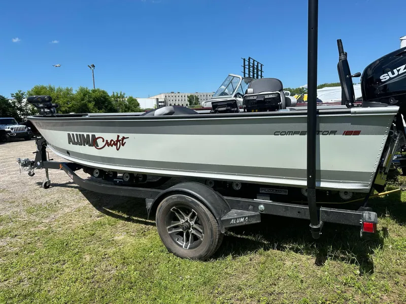 Slide: The Image of 2023 Alumacraft Competitor 185 Tiller boat on trailer, parked outdoors. - 29