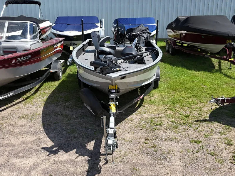 Slide: The Image of 2023 Alumacraft Competitor 185 Tiller boat on trailer, surrounded by other boats. - 3