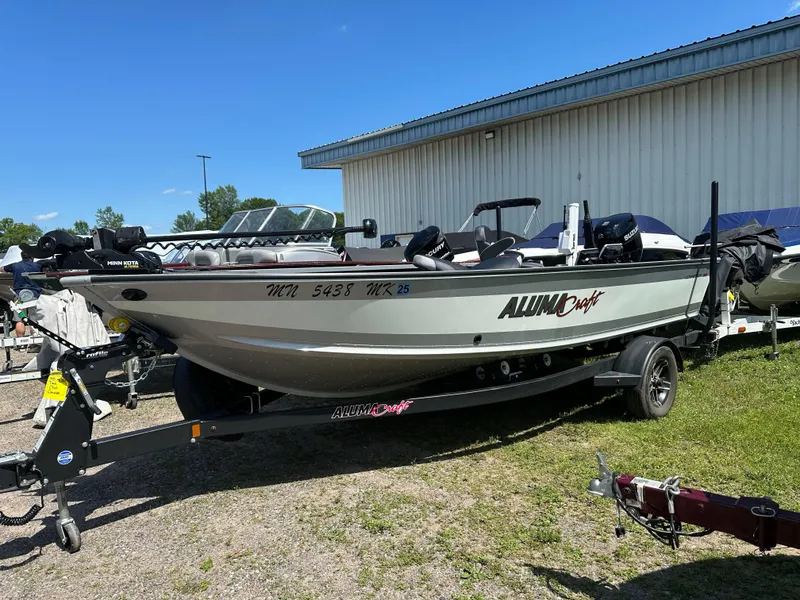 Slide: The Image of 2023 Alumacraft Competitor 185 Tiller boat on trailer, parked outdoors. - 32
