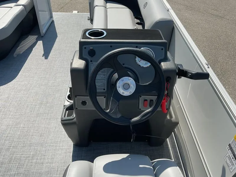 Slide: The Image of 2026 Sun Tracker PB 16 DLX boat steering console with cup holder and seating. - 12