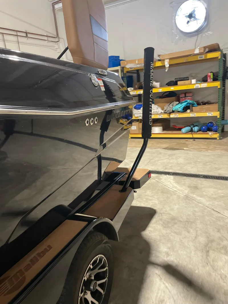 Slide: The Image of 2022 Malibu Wakesetter 23 LSV in a garage, showcasing sleek design and trailer. - 13