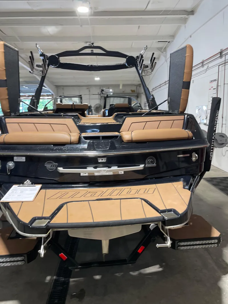 Slide: The Image of 2022 Malibu Wakesetter 23 LSV boat in showroom, featuring tan seating and sleek design. - 15