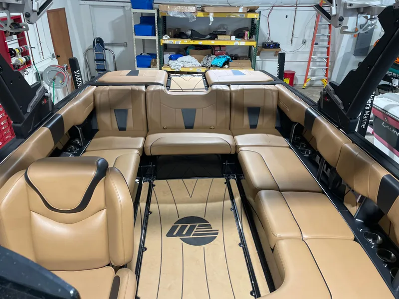 Slide: The Image of 2022 Malibu Wakesetter 23 LSV interior with tan leather seating in a garage setting. - 16