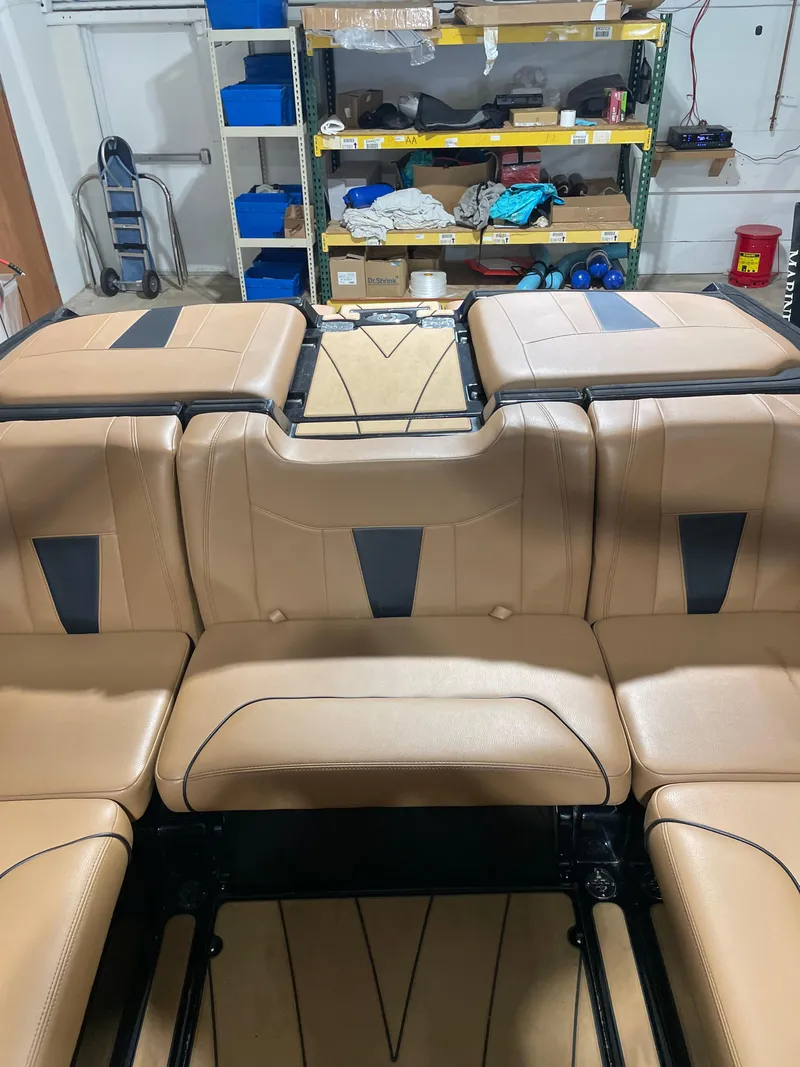 Slide: The Image of 2022 Malibu Wakesetter 23 LSV interior with tan leather seating in a garage setting. - 17