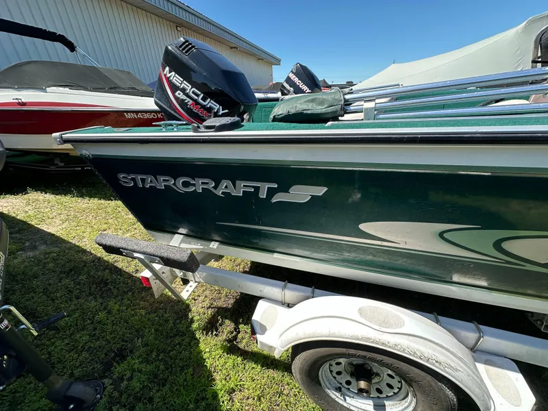 Slide: The Image of 2000 Starcraft Superfisherman 176 DC boat with Mercury outboard motor in showroom. - 2