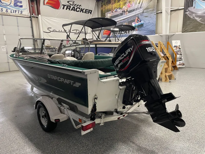 Slide: The Image of 2000 Starcraft Superfisherman 176 DC boat interior with green upholstery and steering console. - 25