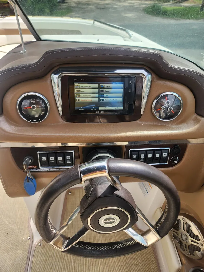 Slide: The Image of 2016 Chaparral 246 SSi boat dashboard with steering wheel and navigation system. - 11