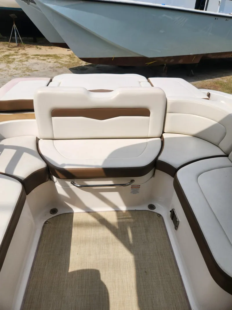 Slide: The Image of 2016 Chaparral 246 SSi boat interior with white and brown seating arrangement. - 20