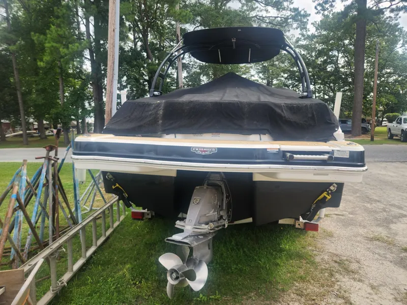 Slide: The Image of 2016 Chaparral 246 SSi boat with cover, parked on grass near trees. - 23