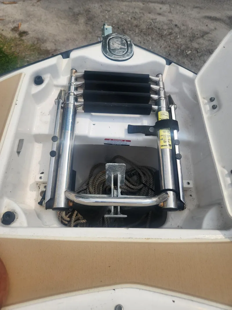 Slide: The Image of 2016 Chaparral 246 SSi boat anchor compartment with ladder and rope storage. - 24