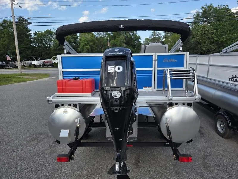Slide: The Image of 2026 Sun Tracker PB 16 DLX pontoon boat with Mercury 50 engine, parked outdoors. - 5