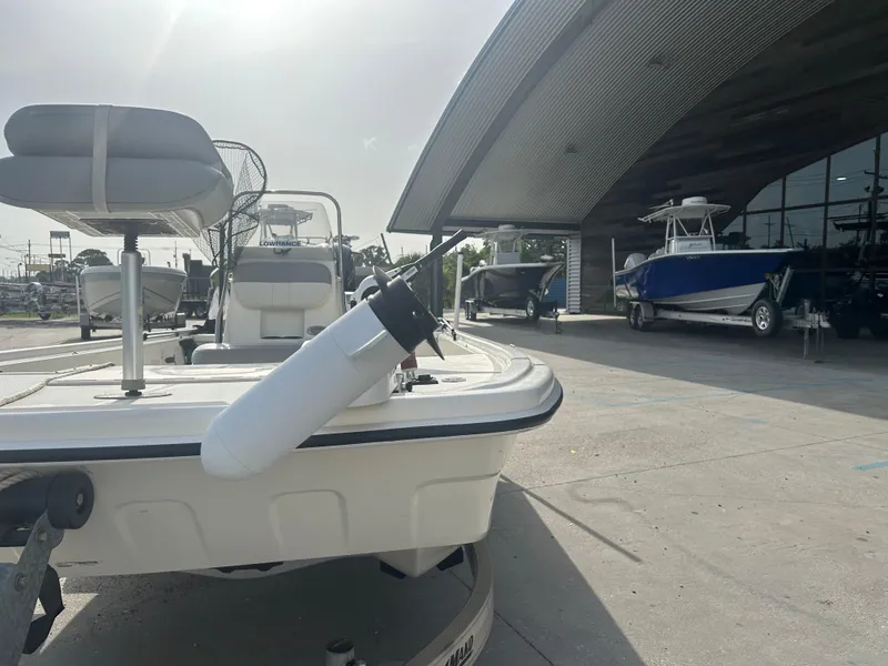 Slide: The Image of 2021 Mako Pro Skiff 19 CC boat displayed at a dealership with other boats. - 8