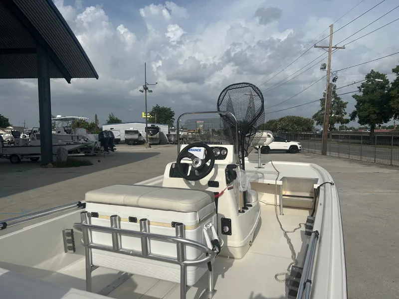 Slide: The Image of 2021 Mako Pro Skiff 19 CC boat with center console and fishing gear, parked outdoors. - 9