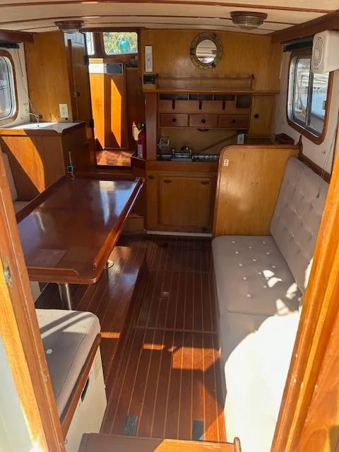 Slide: The Image of 1985 Eagle Trawler interior with wooden furnishings, dining area, and cozy seating. - 10
