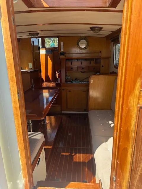 Slide: The Image of Interior of 1985 Eagle Trawler boat with wooden furnishings and seating area. - 11