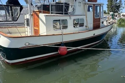 Slide: The Image of 1985 Eagle Trawler boat docked on calm water, featuring classic design and wooden accents. - 14