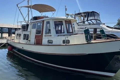 Slide: The Image of 1985 Eagle Trawler boat docked at marina, featuring classic design and spacious cabin. - 16