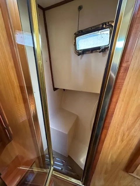 Slide: The Image of 1985 Eagle Trawler bathroom with wooden accents and a small window. - 6