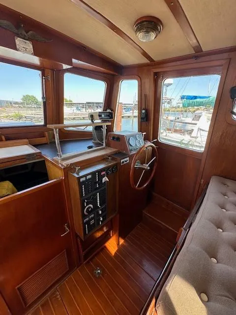 Slide: The Image of 1985 Eagle Trawler interior with wooden helm, control panel, and cushioned seating. - 7
