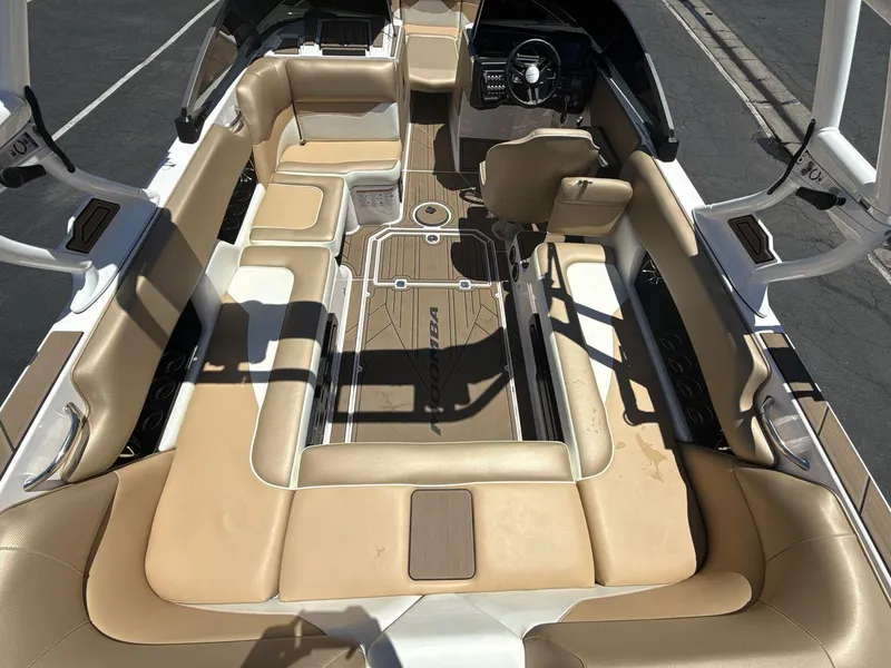 Slide: The Image of 2021 Moomba Mojo boat interior with tan seating and modern dashboard. - 10