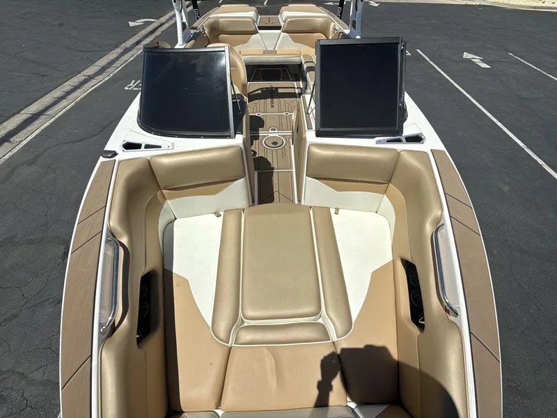 Slide: The Image of 2021 Moomba Mojo boat interior with tan seating and dual windshields. - 12