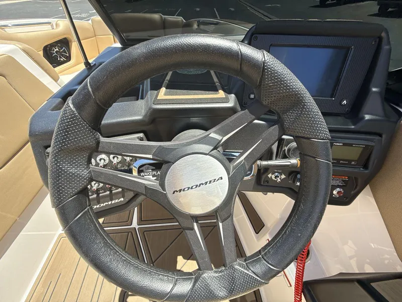 Slide: The Image of Steering wheel of a 2021 Moomba Mojo boat with dashboard controls. - 14