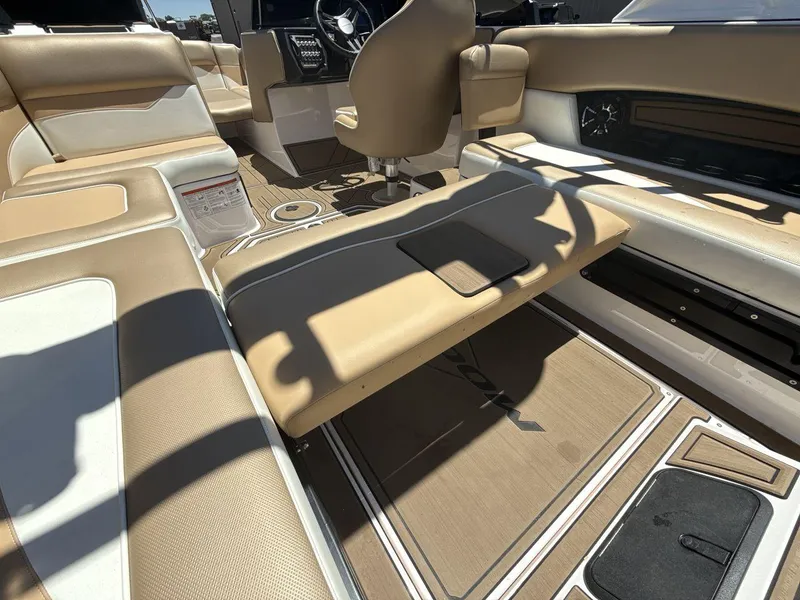 Slide: The Image of 2021 Moomba Mojo boat interior with beige and white seating, steering wheel, and floor details. - 23