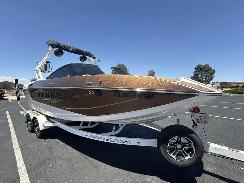 Slide: The Image of 2021 Moomba Mojo boat on trailer under clear blue sky. - 7