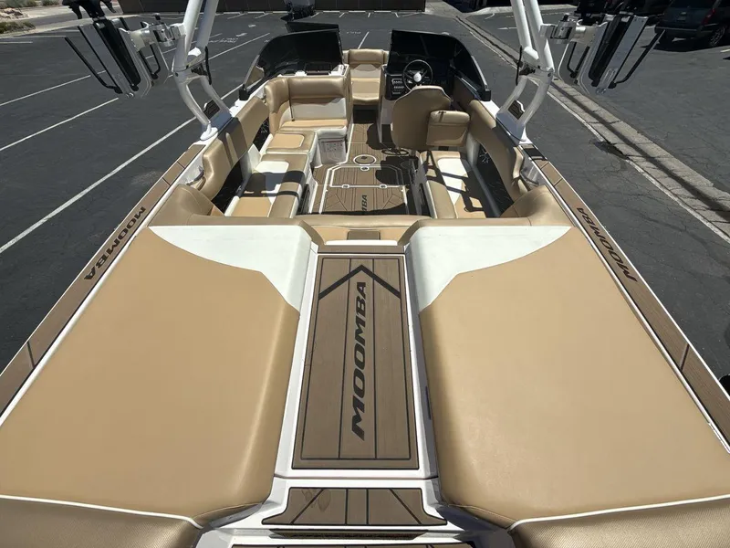 Slide: The Image of 2021 Moomba Mojo boat interior with tan and white seating, parked in a lot. - 9