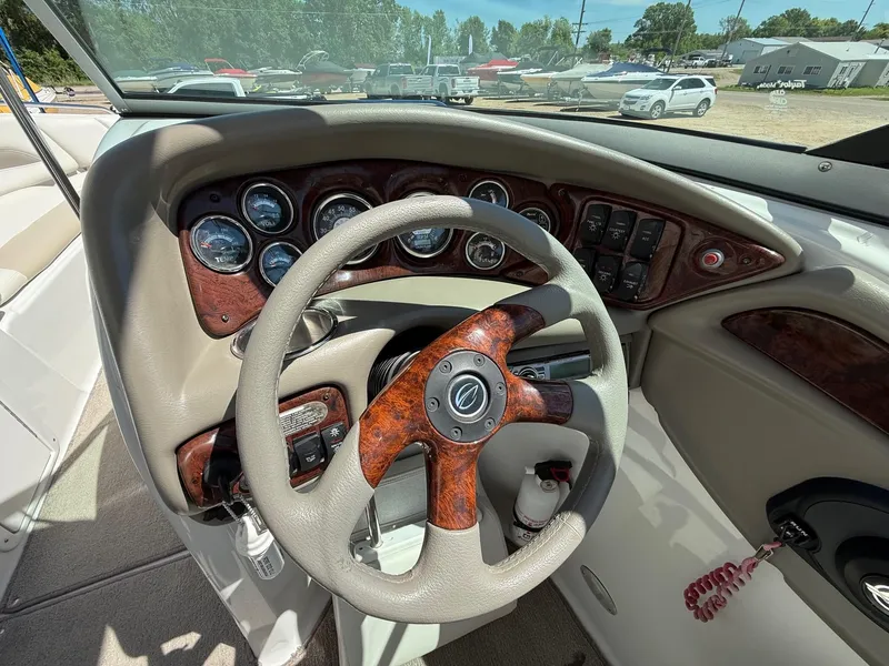 Slide: The Image of 2009 Crownline 270 BR boat dashboard with wood accents and steering wheel. - 15