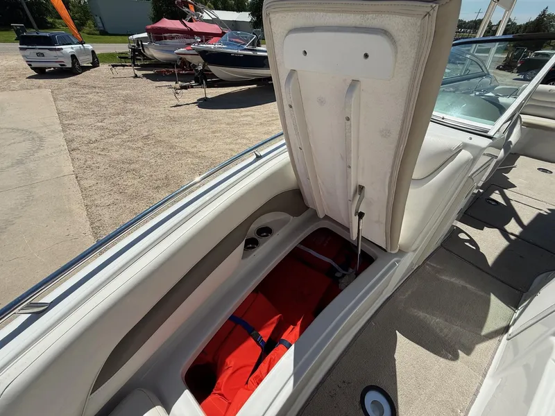 Slide: The Image of 2009 Crownline 270 BR boat interior with open storage compartment and visible life jacket. - 18