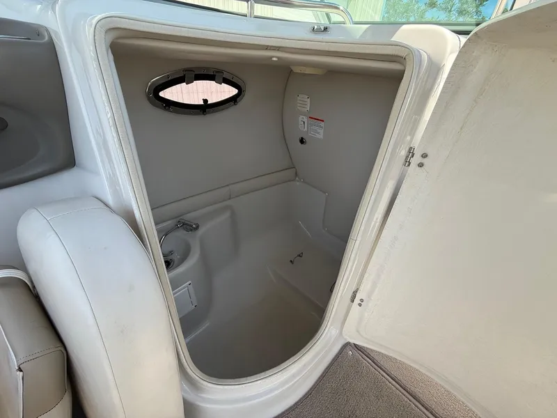 Slide: The Image of 2009 Crownline 270 BR boat interior cabin with open door and small window. - 23