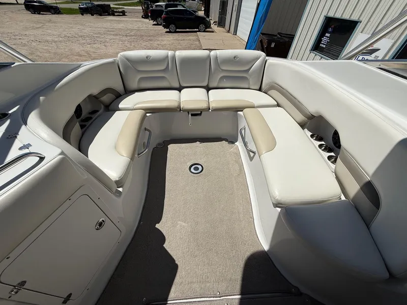 Slide: The Image of 2009 Crownline 270 BR boat interior with spacious seating and beige upholstery. - 25