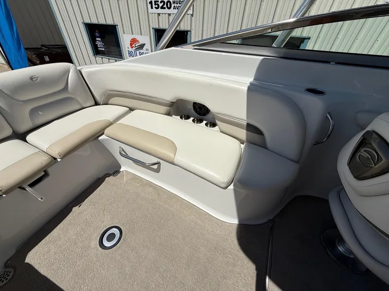 Slide: The Image of 2009 Crownline 270 BR boat interior with beige seating and carpeted floor. - 26