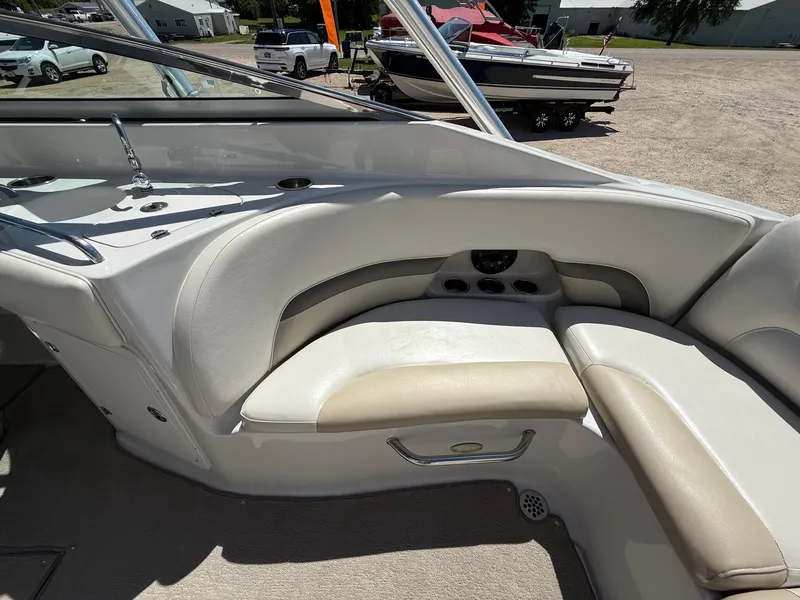 Slide: The Image of 2009 Crownline 270 BR boat interior with beige seating and dashboard view. - 28