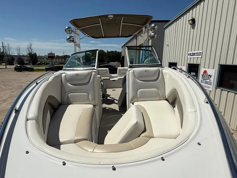 Slide: The Image of 2009 Crownline 270 BR boat with white seating and canopy, parked outdoors. - 3