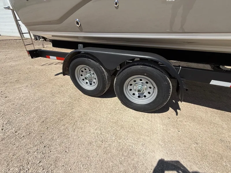 Slide: The Image of Trailer wheels of a 2009 Crownline 270 BR boat on a sandy surface. - 37