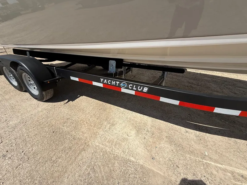 Slide: The Image of Trailer for 2009 Crownline 270 BR boat, labeled "Yacht Club," on sandy ground. - 38