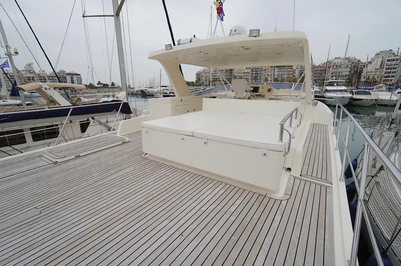 Slide: The Image of Luxury Marlow 61E yacht deck, 2009 model, docked in marina with cityscape background. - 15